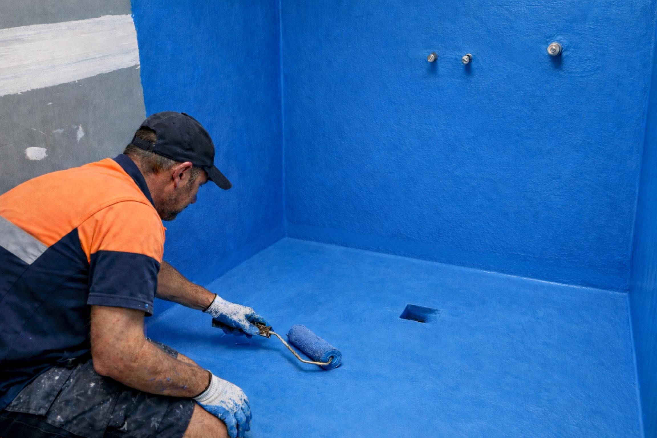 Internal shower waterproofing with liquid membrane showing cove fillet junctions and puddle flange drain detail
